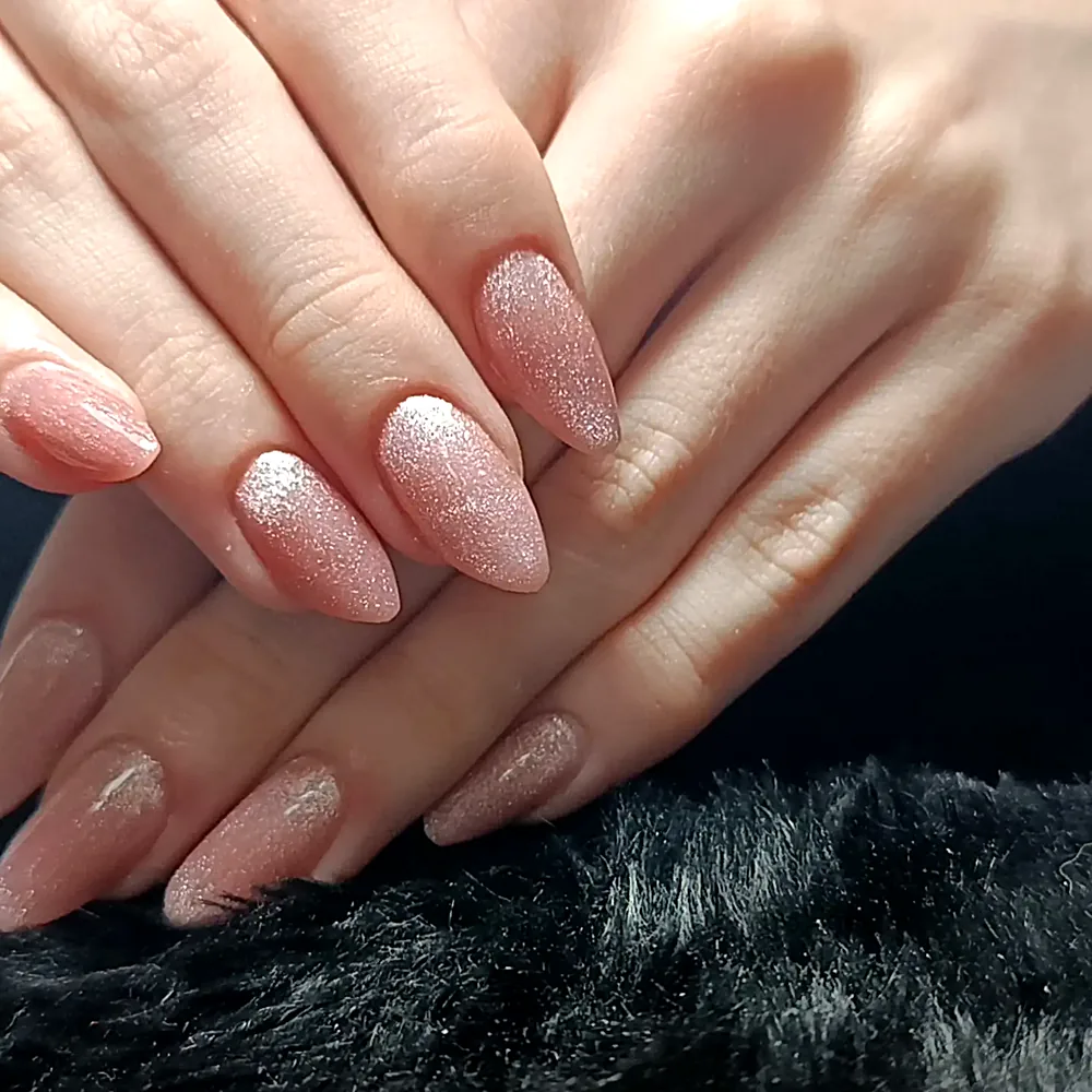 Unhas amendoadas em nude rosado com glitter